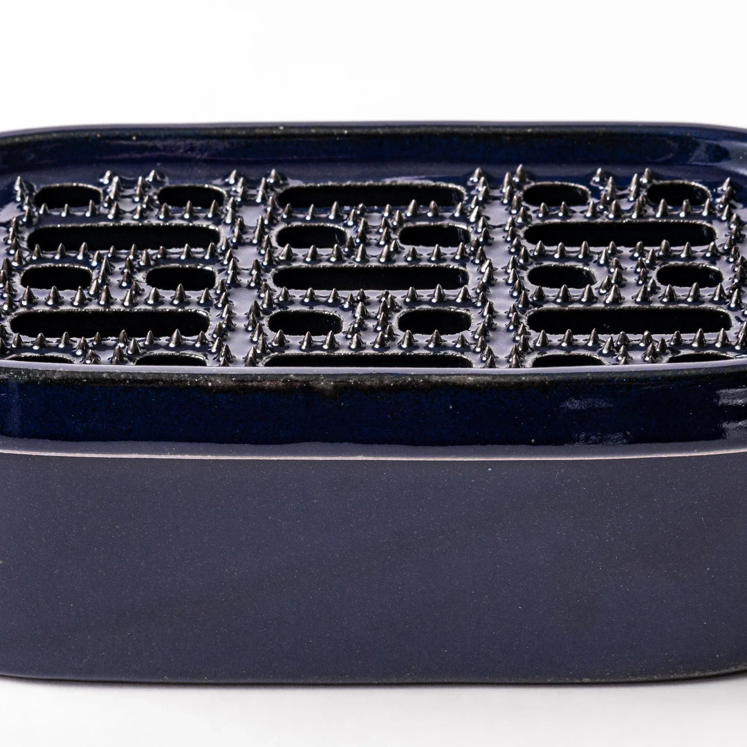 Deep blue Japanese ceramic daikon oroshi grater with built in dish and raised texture for easy grating.