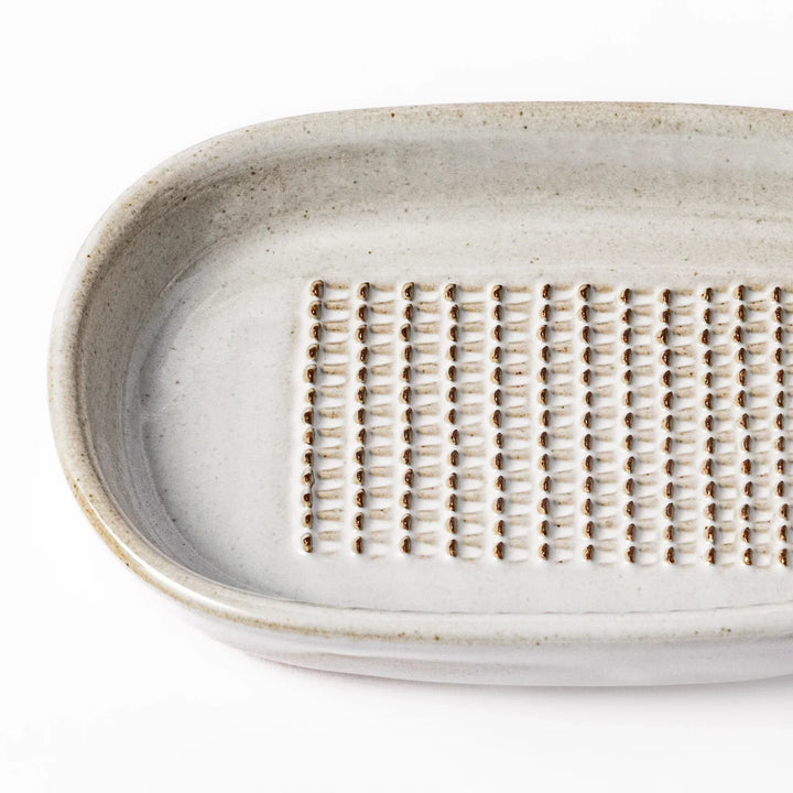 White Japanese ceramic ginger grater dish with natural glaze and raised teeth for grating ginger or garlic.