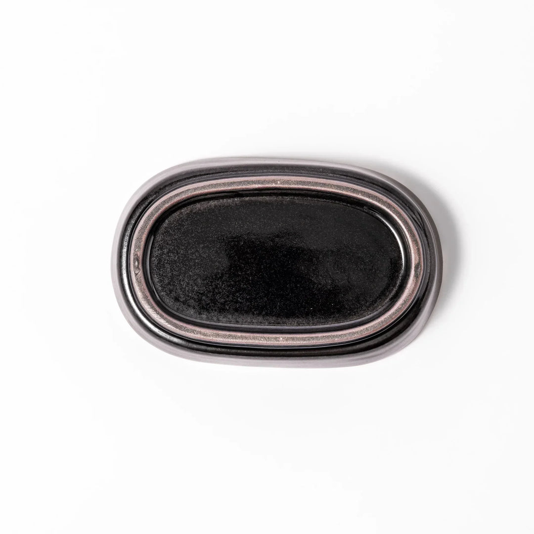 Black ceramic grater dish with raised teeth and shallow oval base, perfect for finely grating ginger, garlic, or daikon.