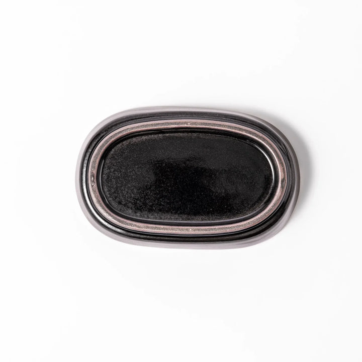 Black ceramic grater dish with raised teeth and shallow oval base, perfect for finely grating ginger, garlic, or daikon.