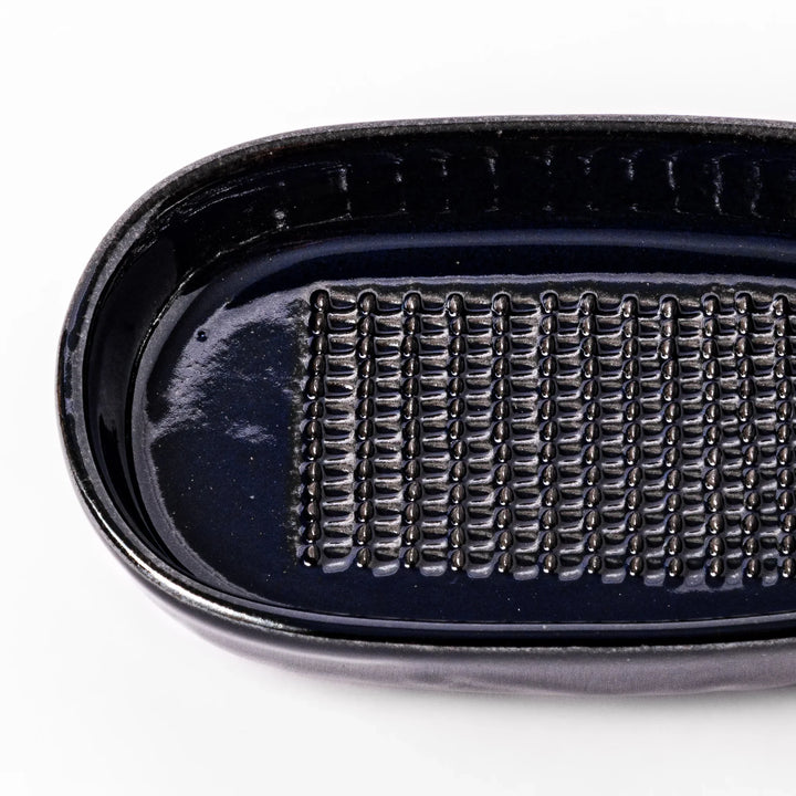Deep blue Japanese ceramic ginger grater dish with raised teeth and shallow base for grating ginger garlic.