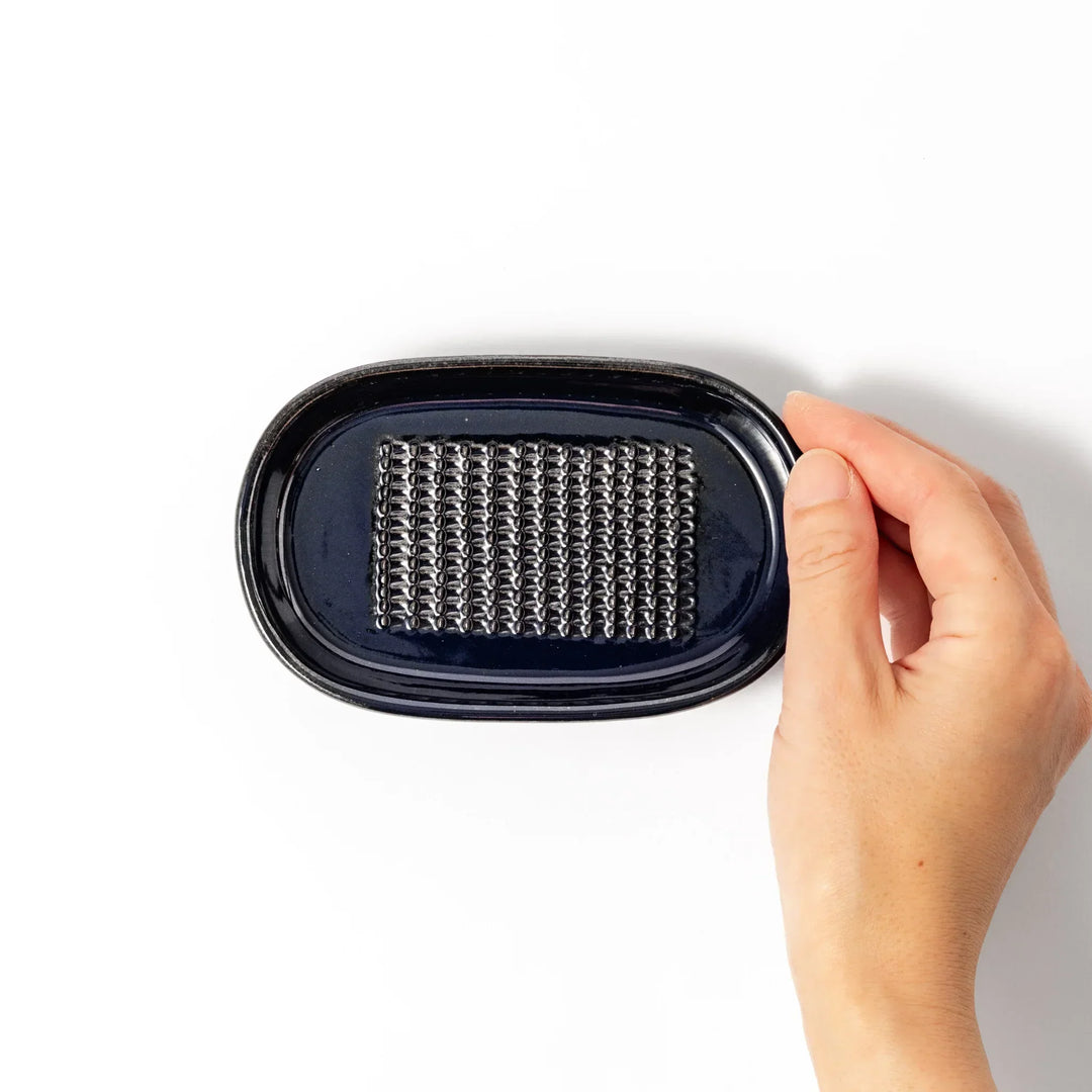 Deep blue Japanese ceramic ginger grater dish with raised teeth and shallow base for grating ginger garlic.