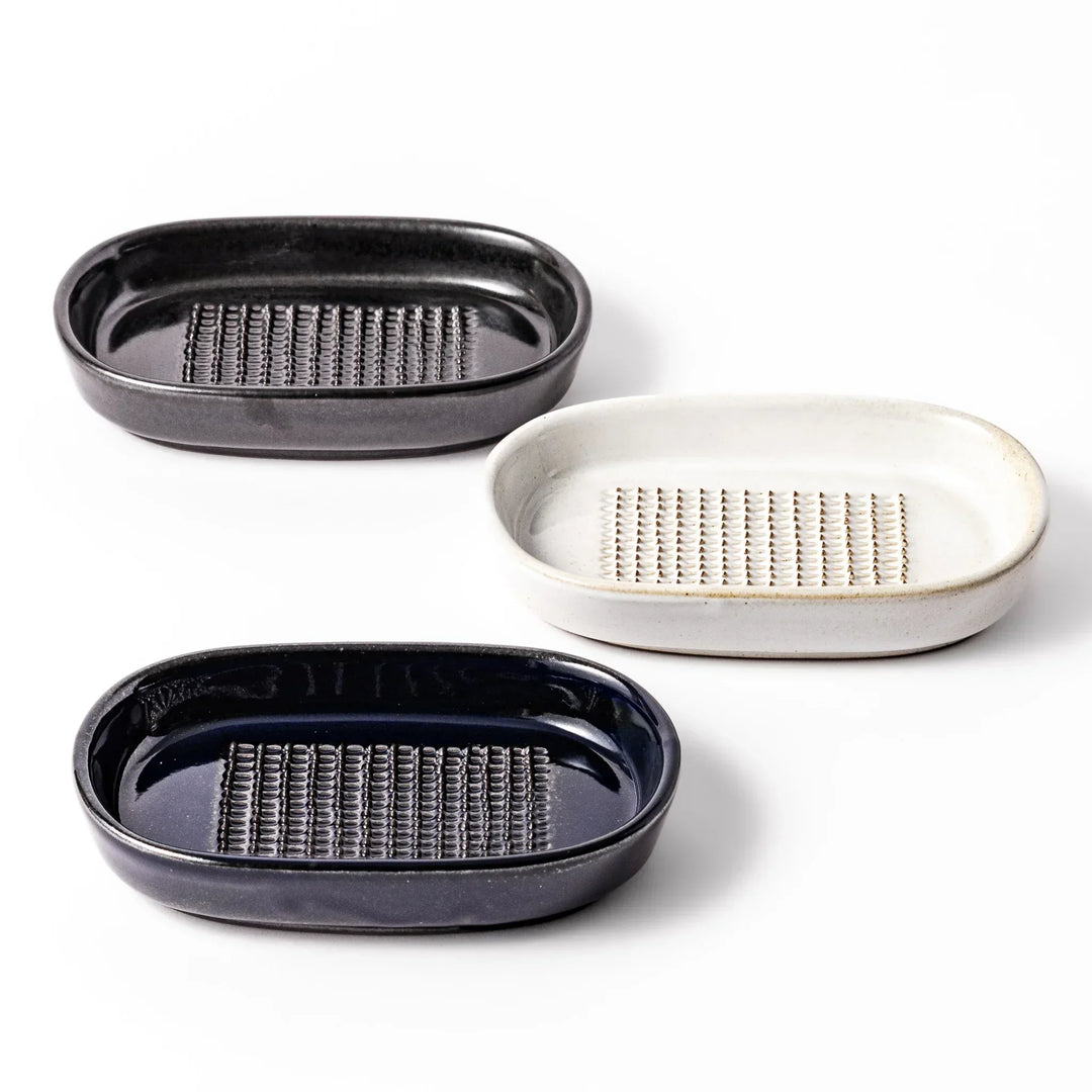 Set of three Japanese ceramic ginger grater dishes in black white and blue with raised teeth for grating.