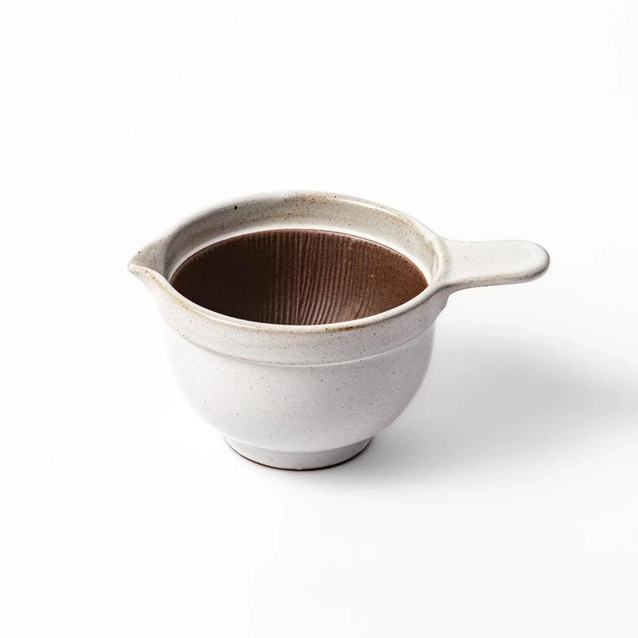 White Japanese ceramic natto suribachi bowl with brown textured interior and side handle for mixing or grinding.