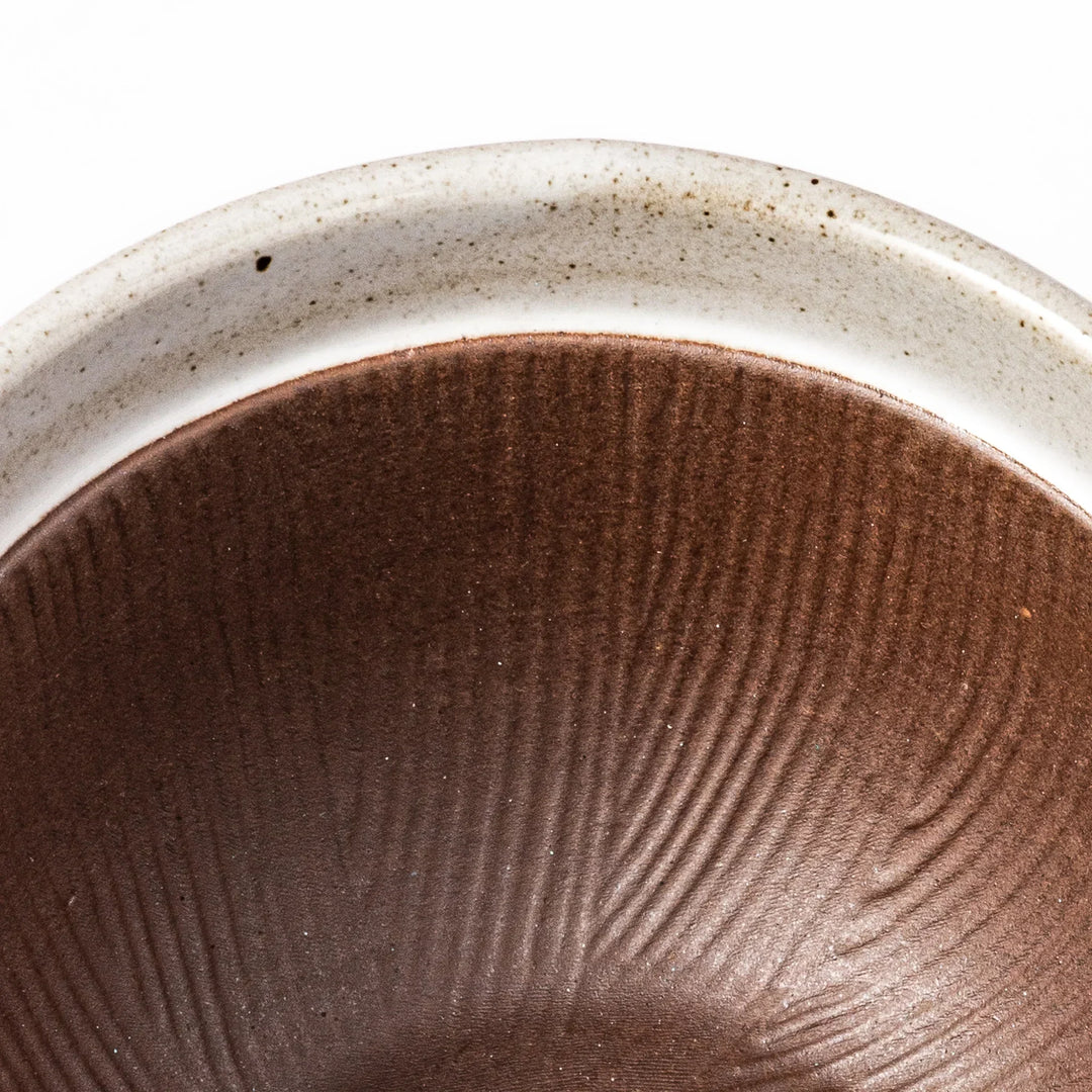 White Japanese ceramic natto suribachi bowl with brown textured interior and side handle for mixing or grinding.