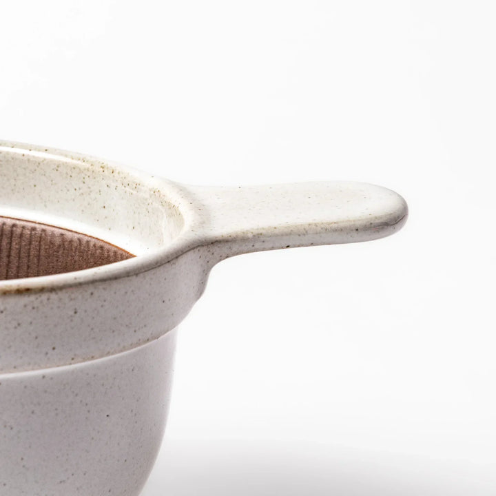 White Japanese ceramic natto suribachi bowl with brown textured interior and side handle for mixing or grinding.