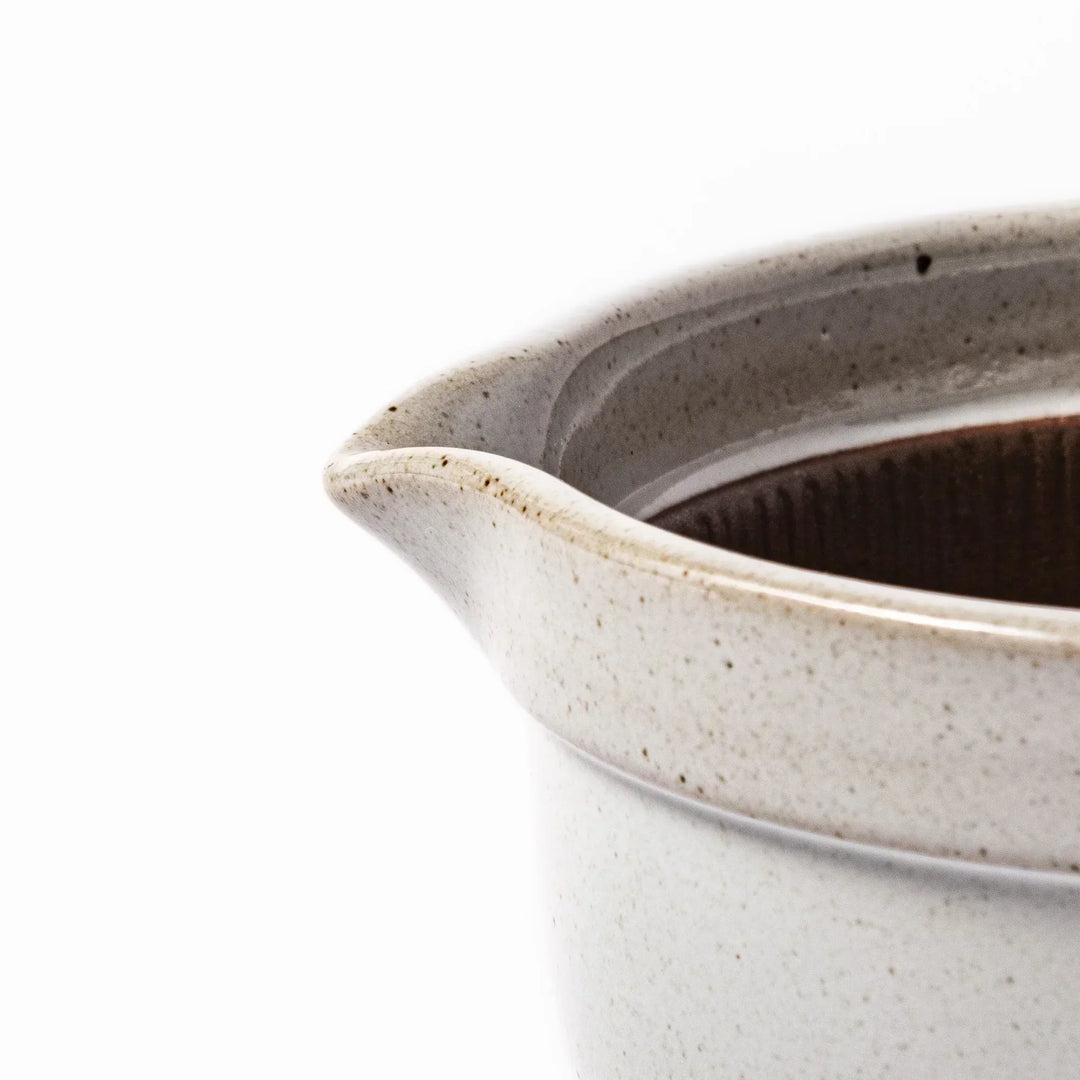 White Japanese ceramic natto suribachi bowl with brown textured interior and side handle for mixing or grinding.