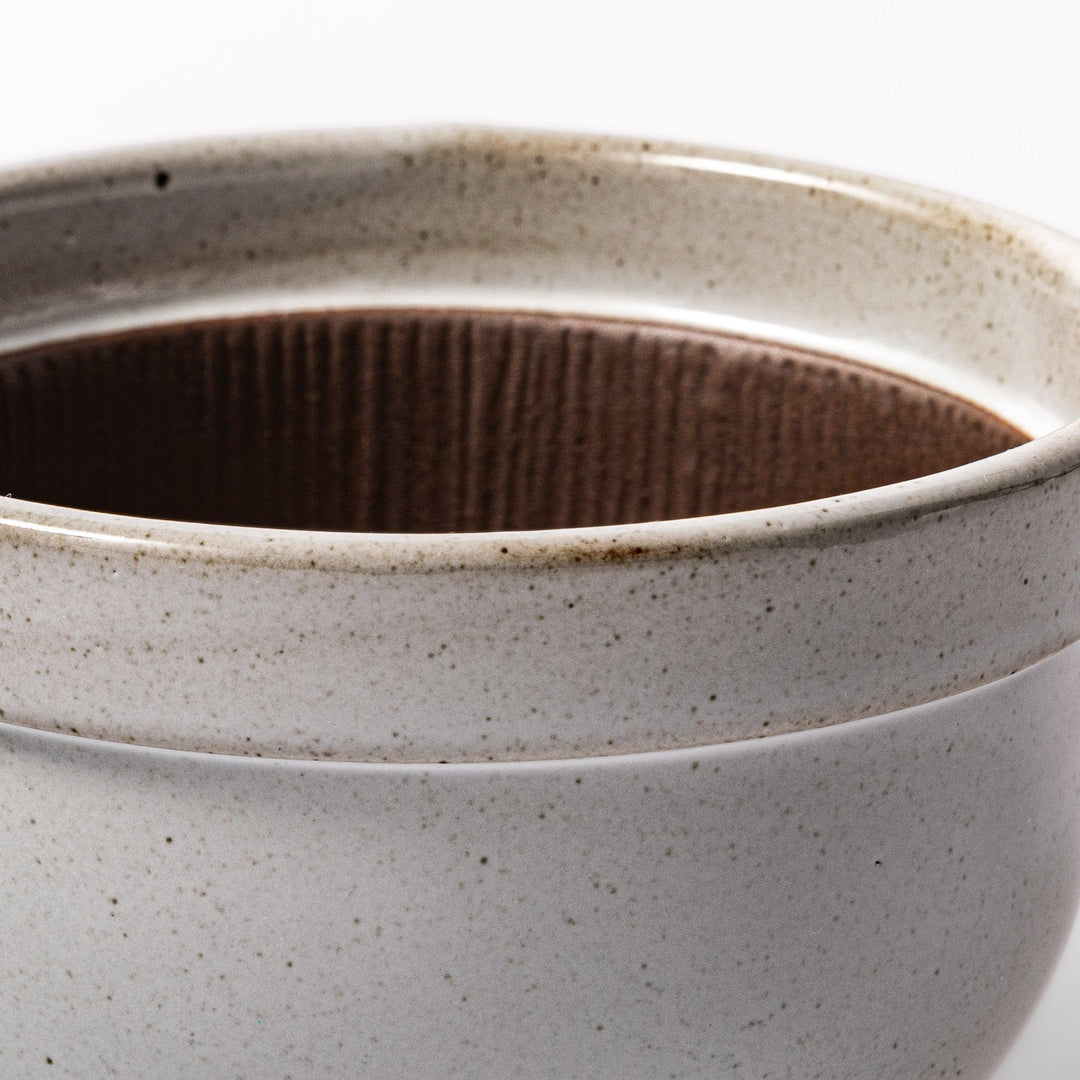 White Japanese ceramic natto suribachi bowl with brown textured interior and side handle for mixing or grinding.