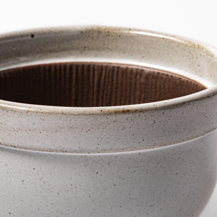 White Japanese ceramic natto suribachi bowl with brown textured interior and side handle for mixing or grinding.