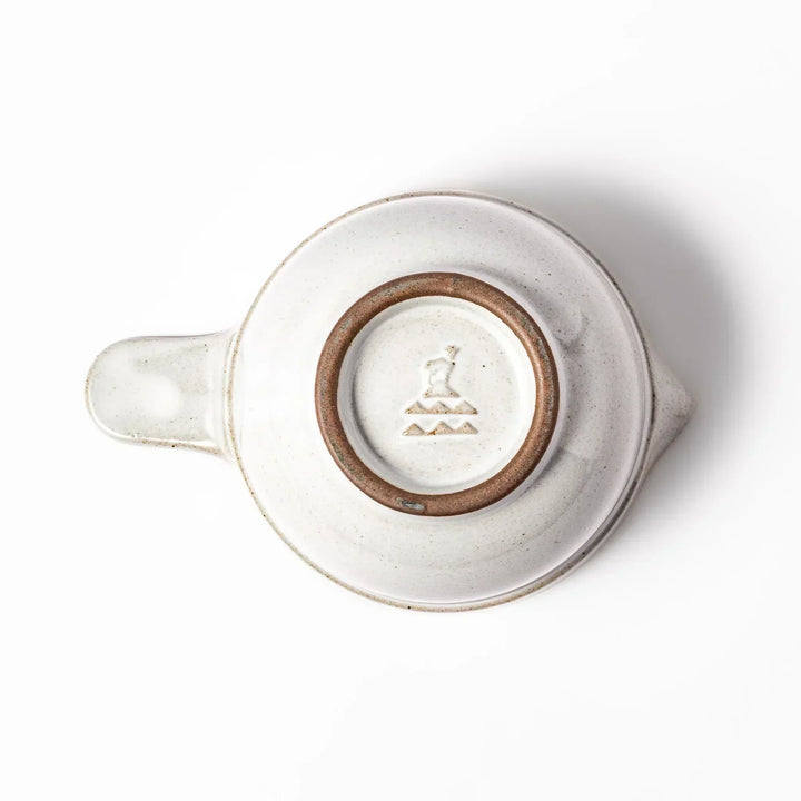 White Japanese ceramic natto suribachi bowl with brown textured interior and side handle for mixing or grinding.