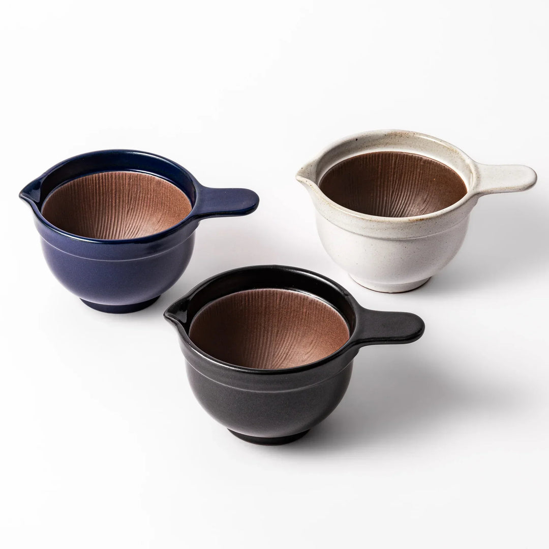 Deep blue Japanese ceramic natto suribachi bowl with ridged brown interior and handle for mixing or grinding.