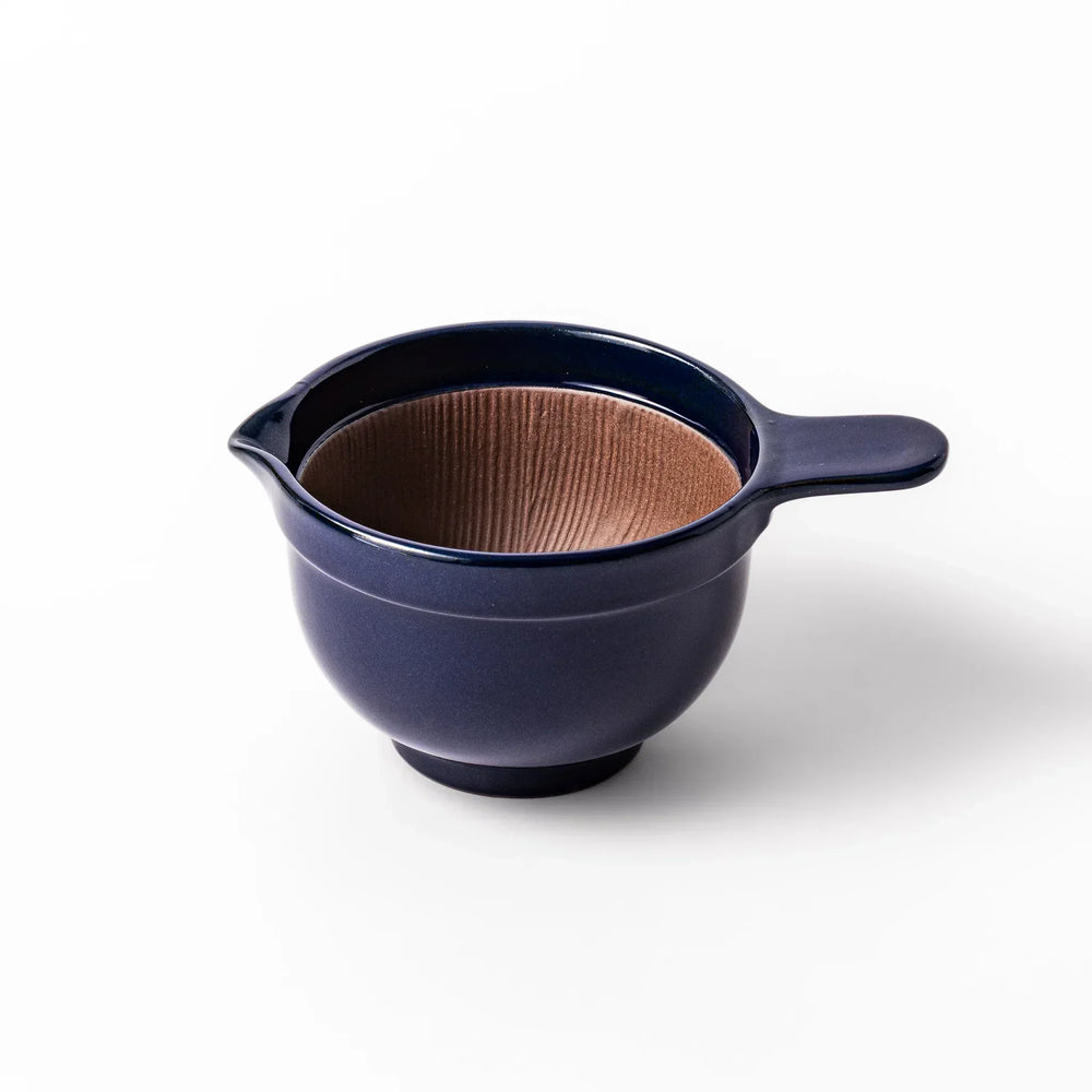 Deep blue Japanese ceramic natto suribachi bowl with ridged brown interior and handle for mixing or grinding.