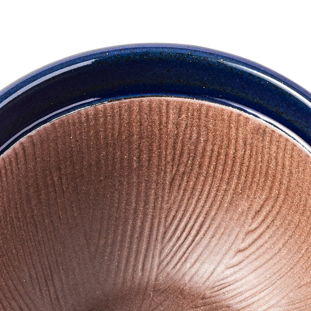 Deep blue Japanese ceramic natto suribachi bowl with ridged brown interior and handle for mixing or grinding.
