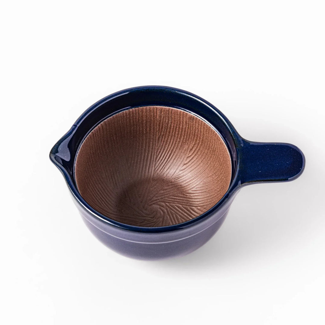 Deep blue Japanese ceramic natto suribachi bowl with ridged brown interior and handle for mixing or grinding.