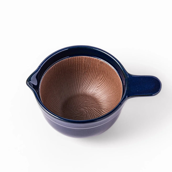 Deep blue Japanese ceramic natto suribachi bowl with ridged brown interior and handle for mixing or grinding.