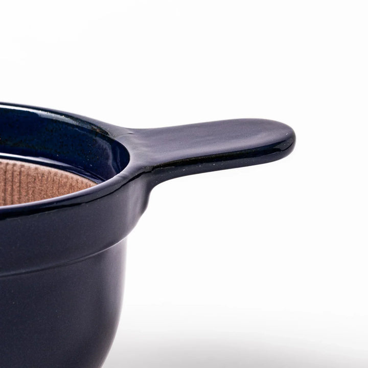 Deep blue Japanese ceramic natto suribachi bowl with ridged brown interior and handle for mixing or grinding.
