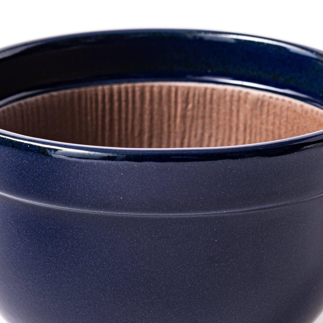 Deep blue Japanese ceramic natto suribachi bowl with ridged brown interior and handle for mixing or grinding.