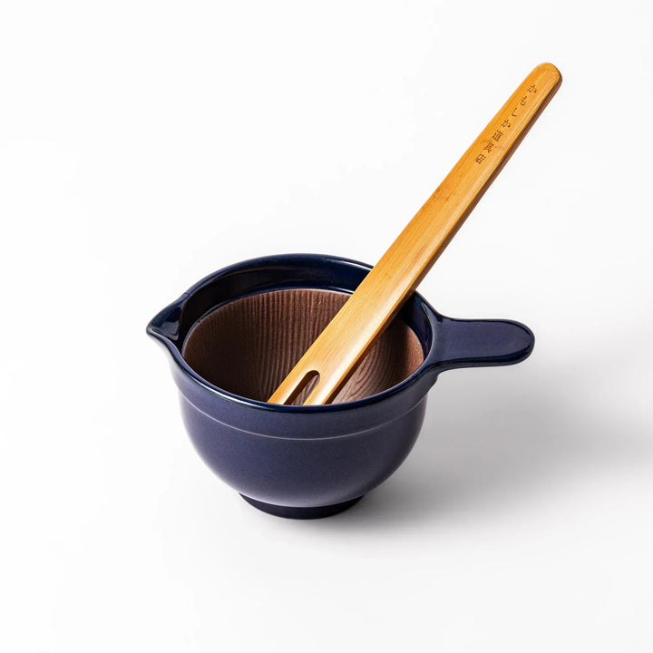 Deep blue Japanese ceramic natto suribachi bowl with ridged brown interior and handle for mixing or grinding.