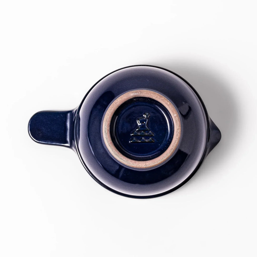 Deep blue Japanese ceramic natto suribachi bowl with ridged brown interior and handle for mixing or grinding.
