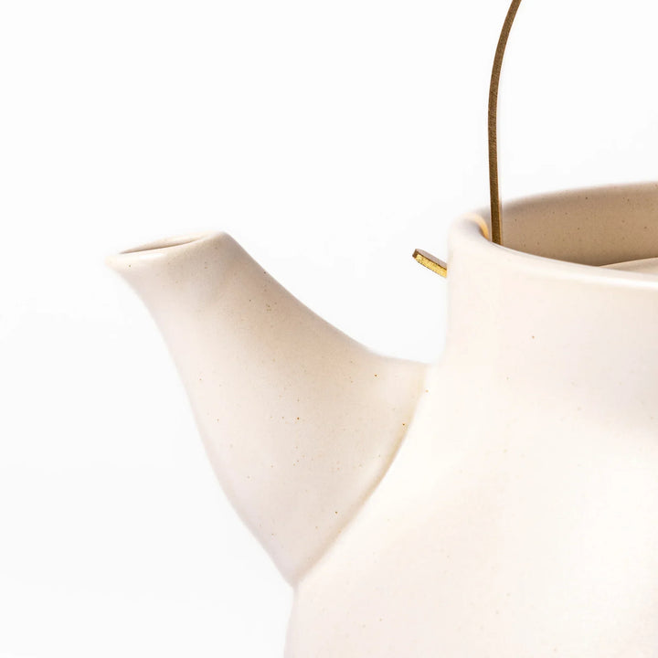 White Japanese ceramic stovetop kettle with matte finish and brass handle for daily tea brewing elegance.
