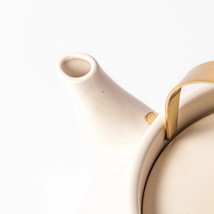 White Japanese ceramic stovetop kettle with matte finish and brass handle for daily tea brewing elegance.