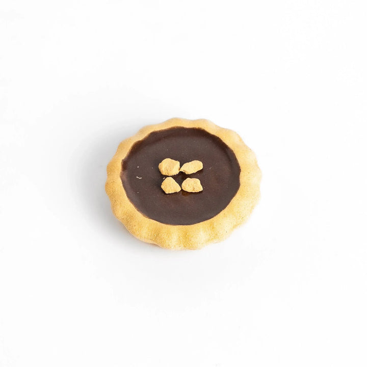 Chocolate tart-shaped chopstick rest with realistic crust and filling, adding a sweet accent to your dining table.