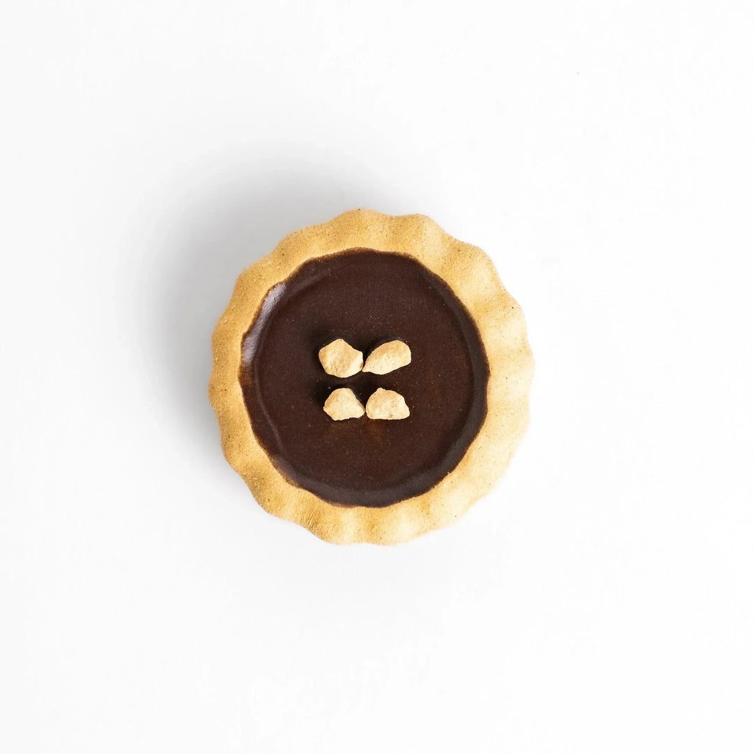 Chocolate tart-shaped chopstick rest with realistic crust and filling, adding a sweet accent to your dining table.