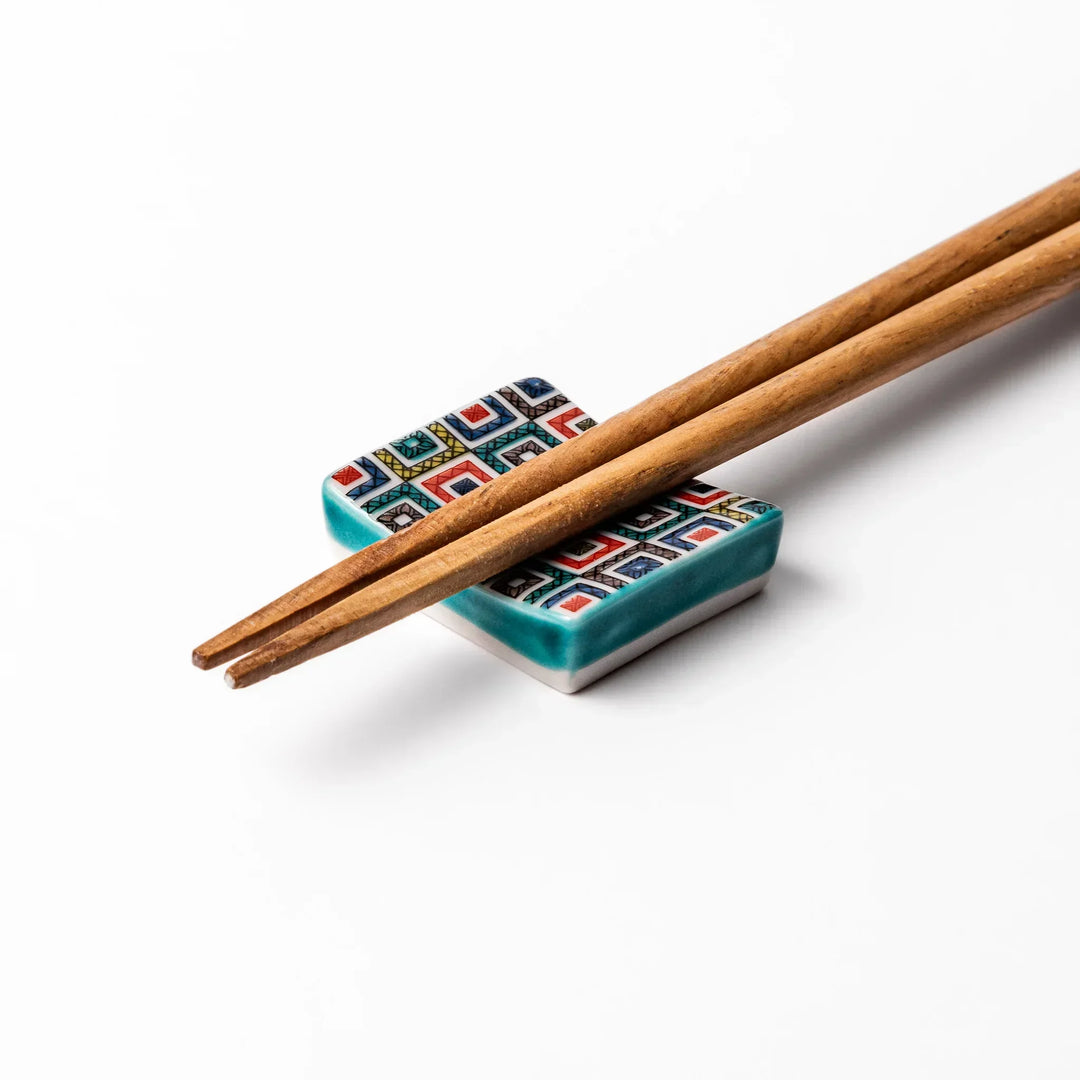 Japanese ceramic chopstick rest with colorful cobblestone mosaic pattern in red blue green yellow and black.