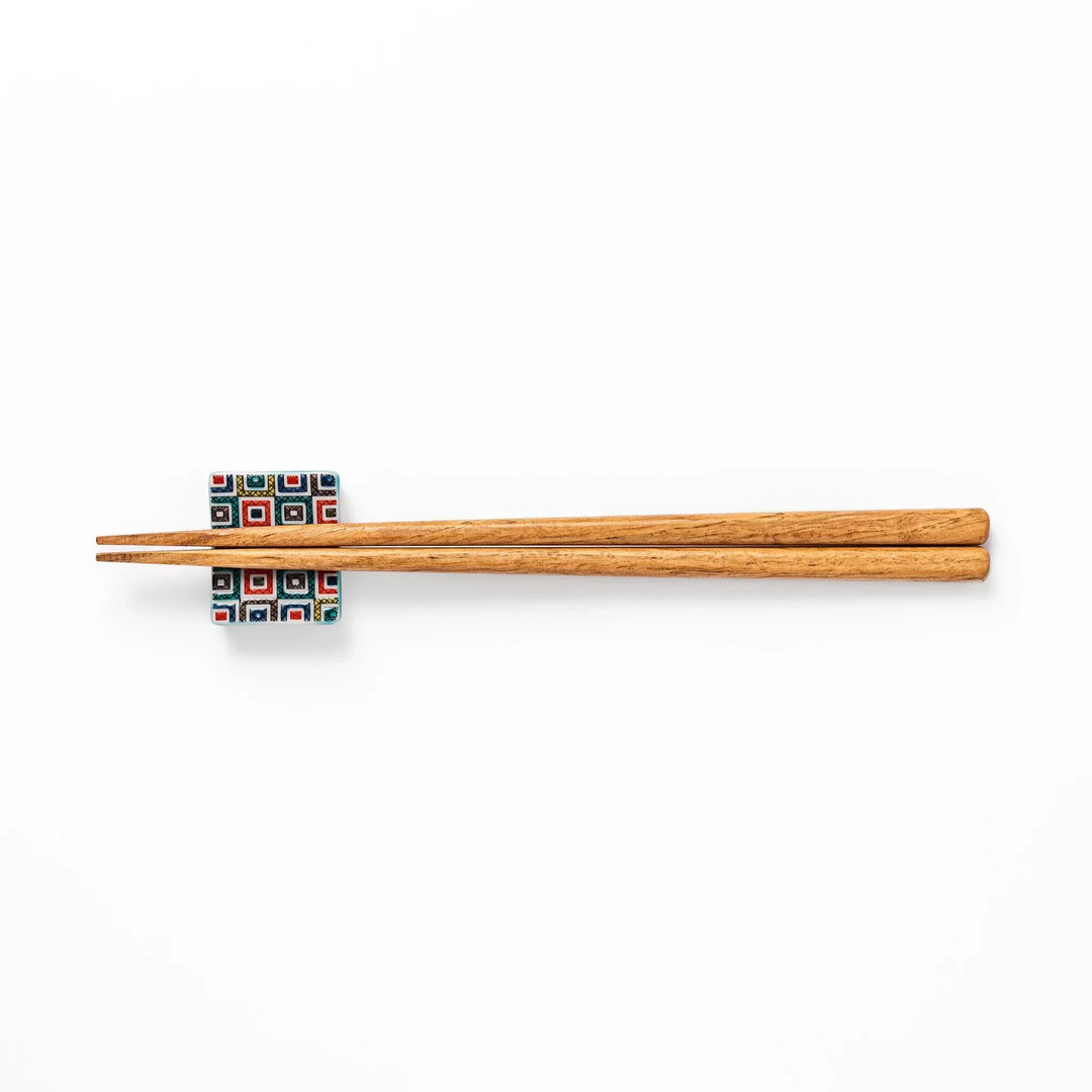 Japanese ceramic chopstick rest with colorful cobblestone mosaic pattern in red blue green yellow and black.