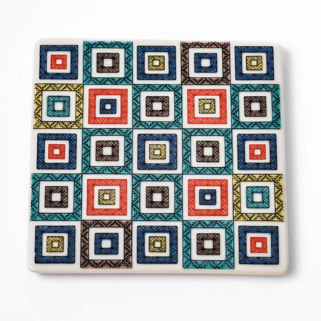 Square Japanese ceramic coaster with colorful cobblestone mosaic pattern in red blue green yellow and black.