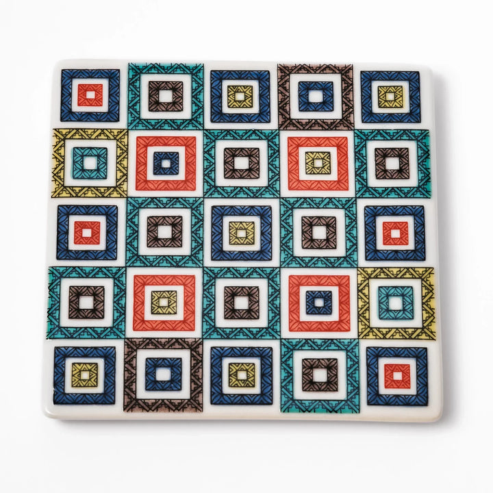 Square Japanese ceramic coaster with colorful cobblestone mosaic pattern in red blue green yellow and black.