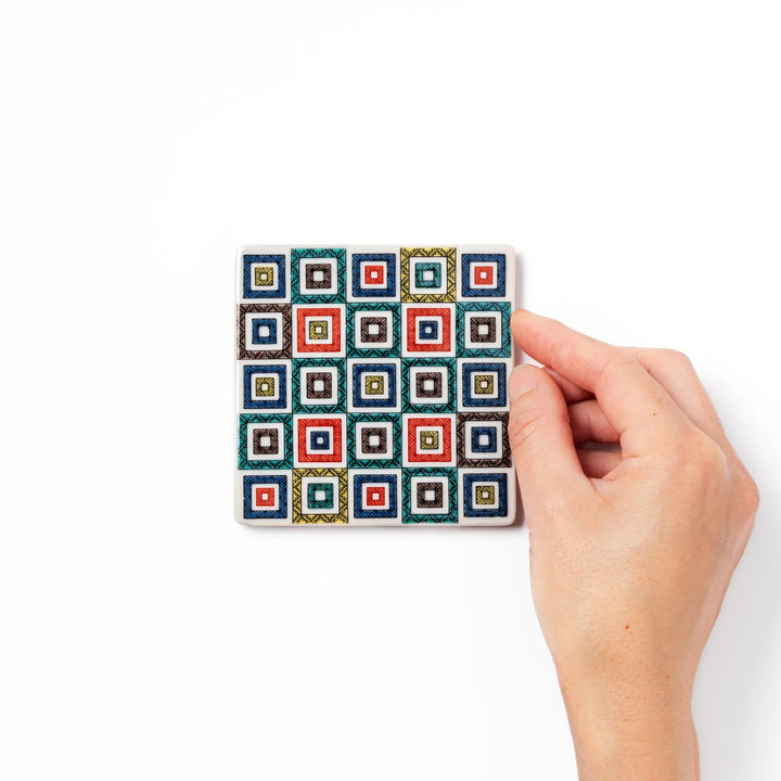 Square Japanese ceramic coaster with colorful cobblestone mosaic pattern in red blue green yellow and black.