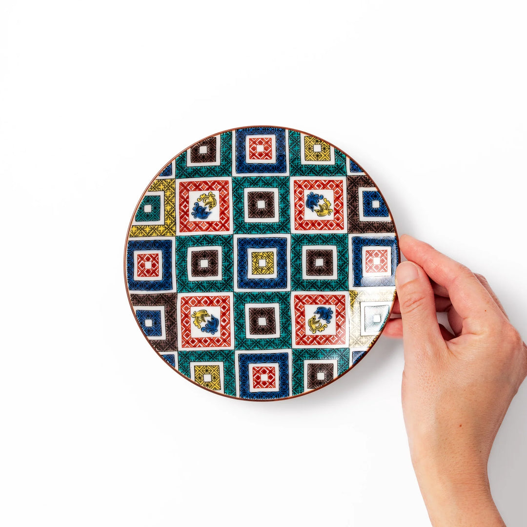 Colorful Japanese porcelain dessert plate with geometric mosaic squares in red green yellow blue and black.