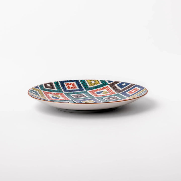 Colorful Japanese porcelain dessert plate with geometric mosaic squares in red green yellow blue and black.
