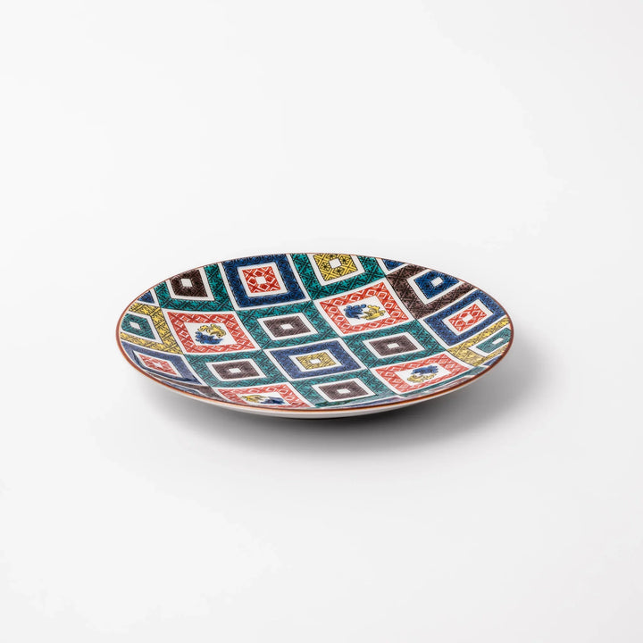 Colorful Japanese porcelain dessert plate with geometric mosaic squares in red green yellow blue and black.