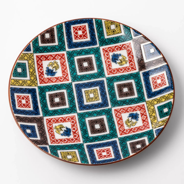 Colorful Japanese porcelain dessert plate with geometric mosaic squares in red green yellow blue and black.