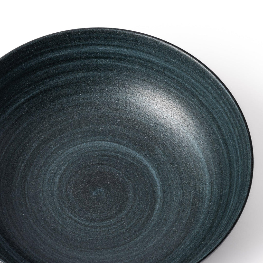 Deep navy ceramic bowl with subtle concentric lines and matte finish, softly flared rim against a white background