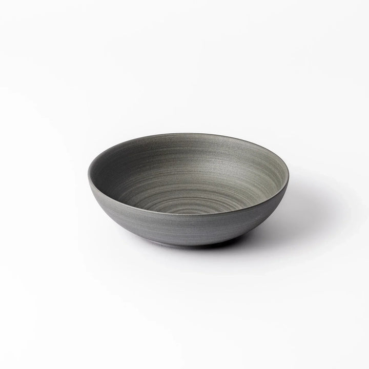 Smooth matte grey ceramic bowl with fine concentric ridges and gently flared rim against a clean white background
