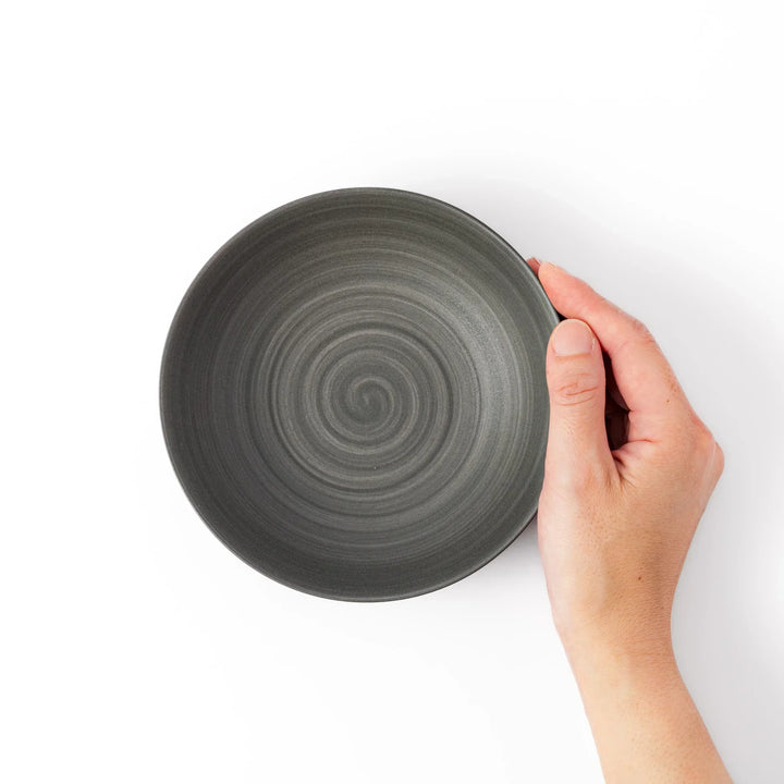 Smooth matte grey ceramic bowl with fine concentric ridges and gently flared rim against a clean white background