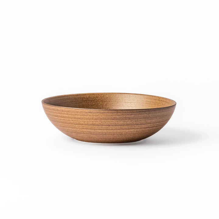 Matte beige ceramic bowl with a warm, woodgrain-like texture and softly curved shape, set against a white background.