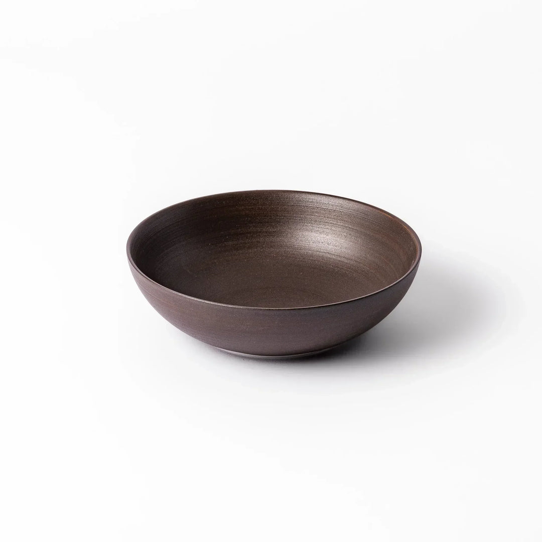 Matte brown ceramic bowl with a gently curved form and subtle textured finish, placed on a white background.