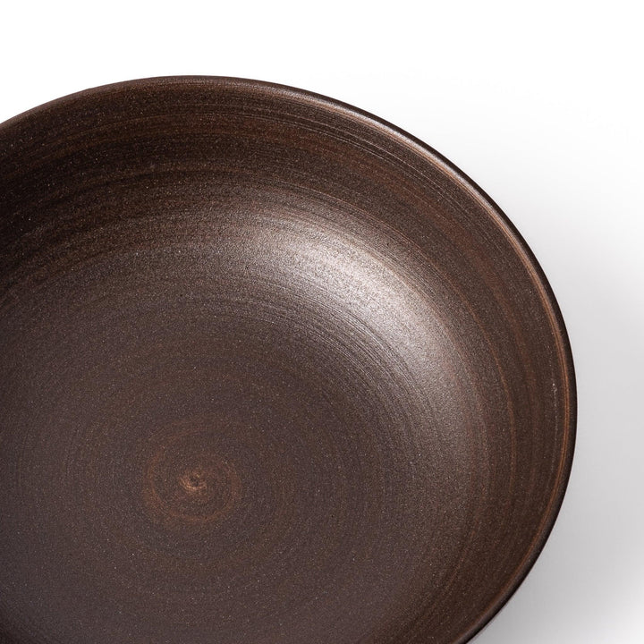 Matte brown ceramic bowl with a gently curved form and subtle textured finish, placed on a white background.