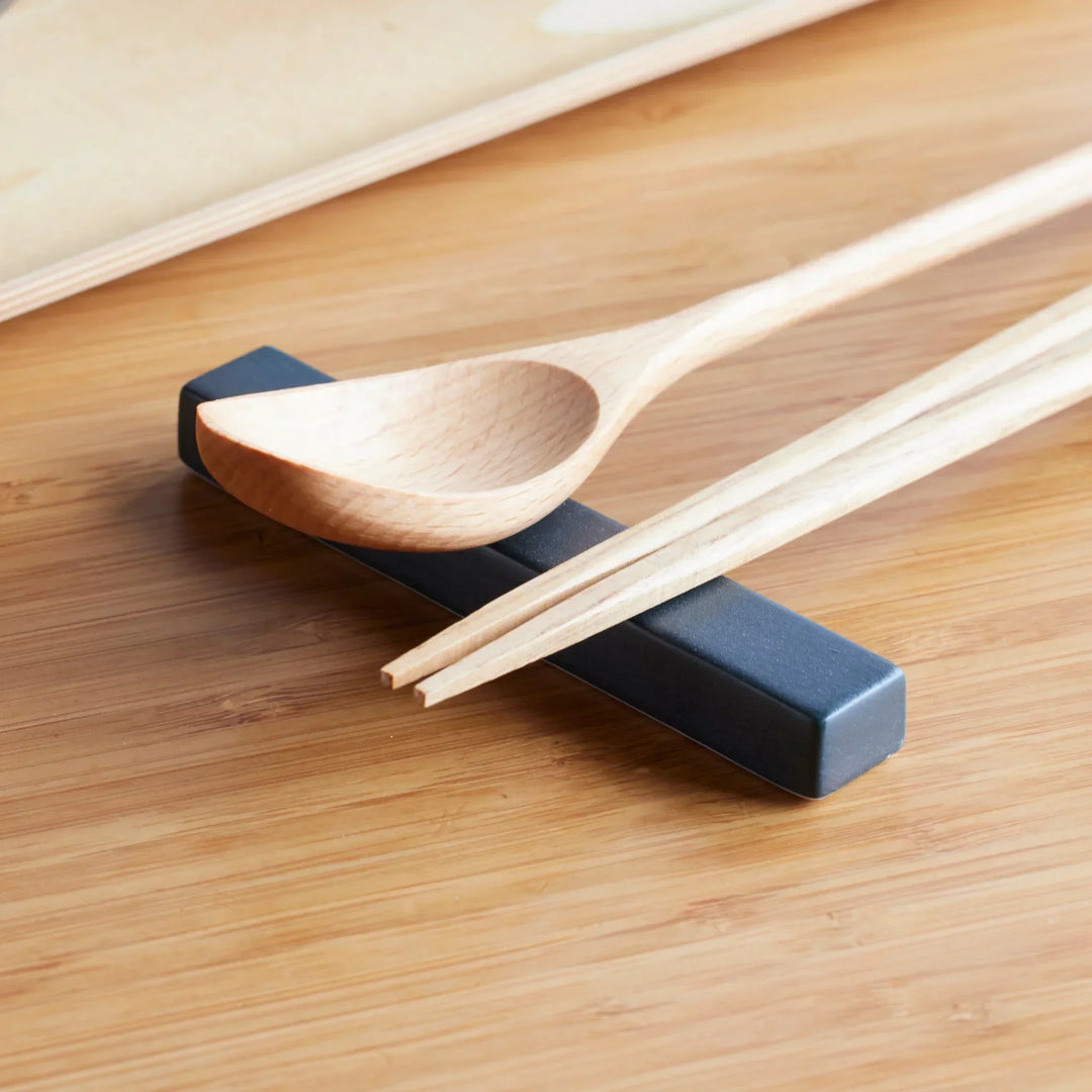 Cozy Japandi Chopstick Rest holding natural wood chopsticks and a matching wooden soup spoon on a bamboo surface.
