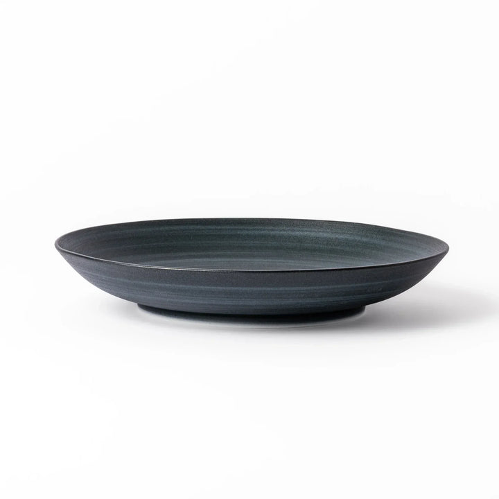 Matte navy blue salad plate with swirling concentric texture and softly curved rim for a calm, modern feel.