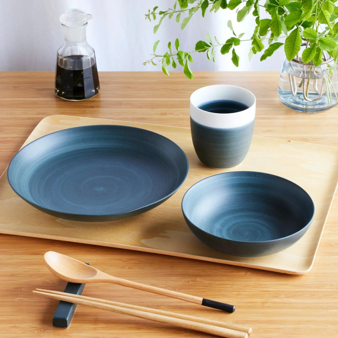 Navy blue dinnerware set with gradient design, including plate, bowl, and cup, paired with wooden utensils.