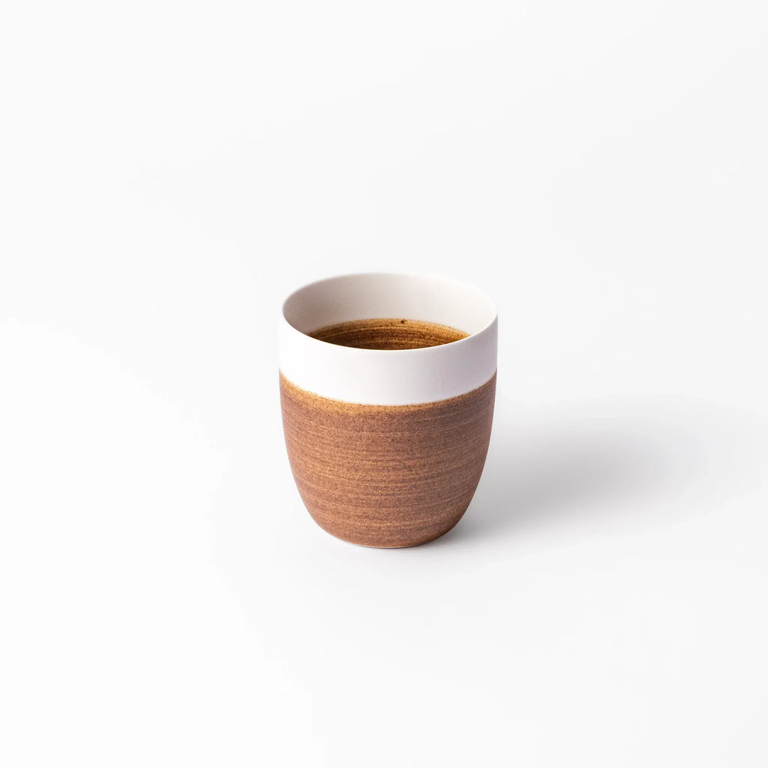 Two-tone ceramic tea cup with a matte ivory rim and warm caramel-toned base. Perfect for cozy sips and Japandi-style tables.