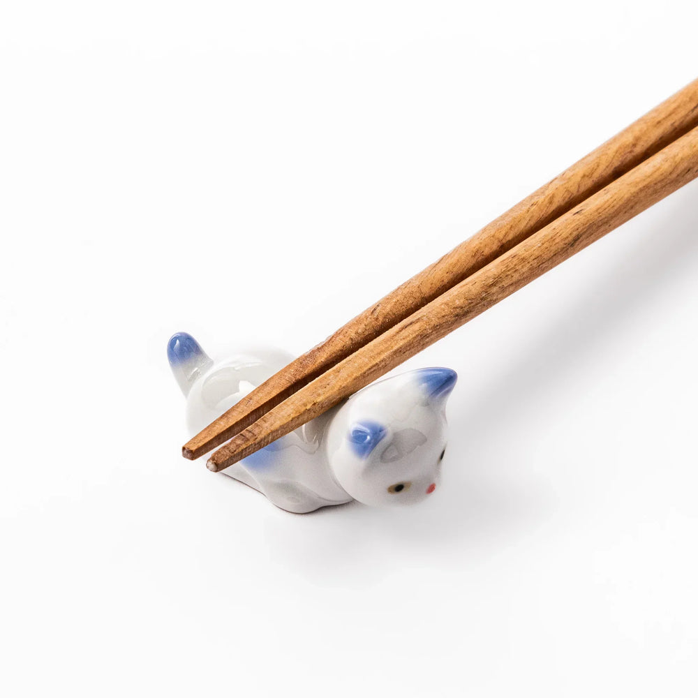 White porcelain kitten-shaped chopstick rest with blue-tipped ears, tail, and body accents, featuring a small red nose.