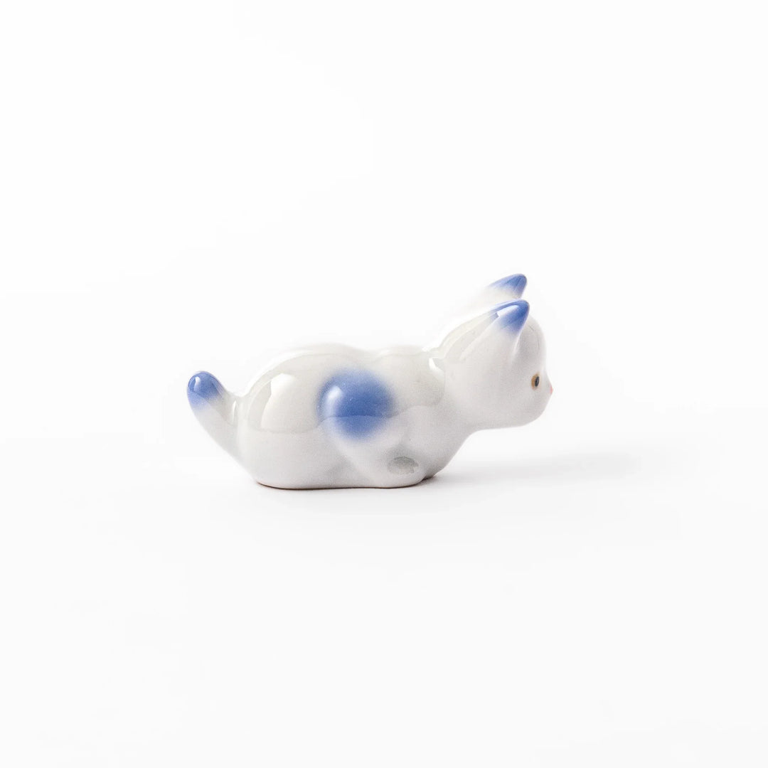 White porcelain kitten-shaped chopstick rest with blue-tipped ears, tail, and body accents, featuring a small red nose.