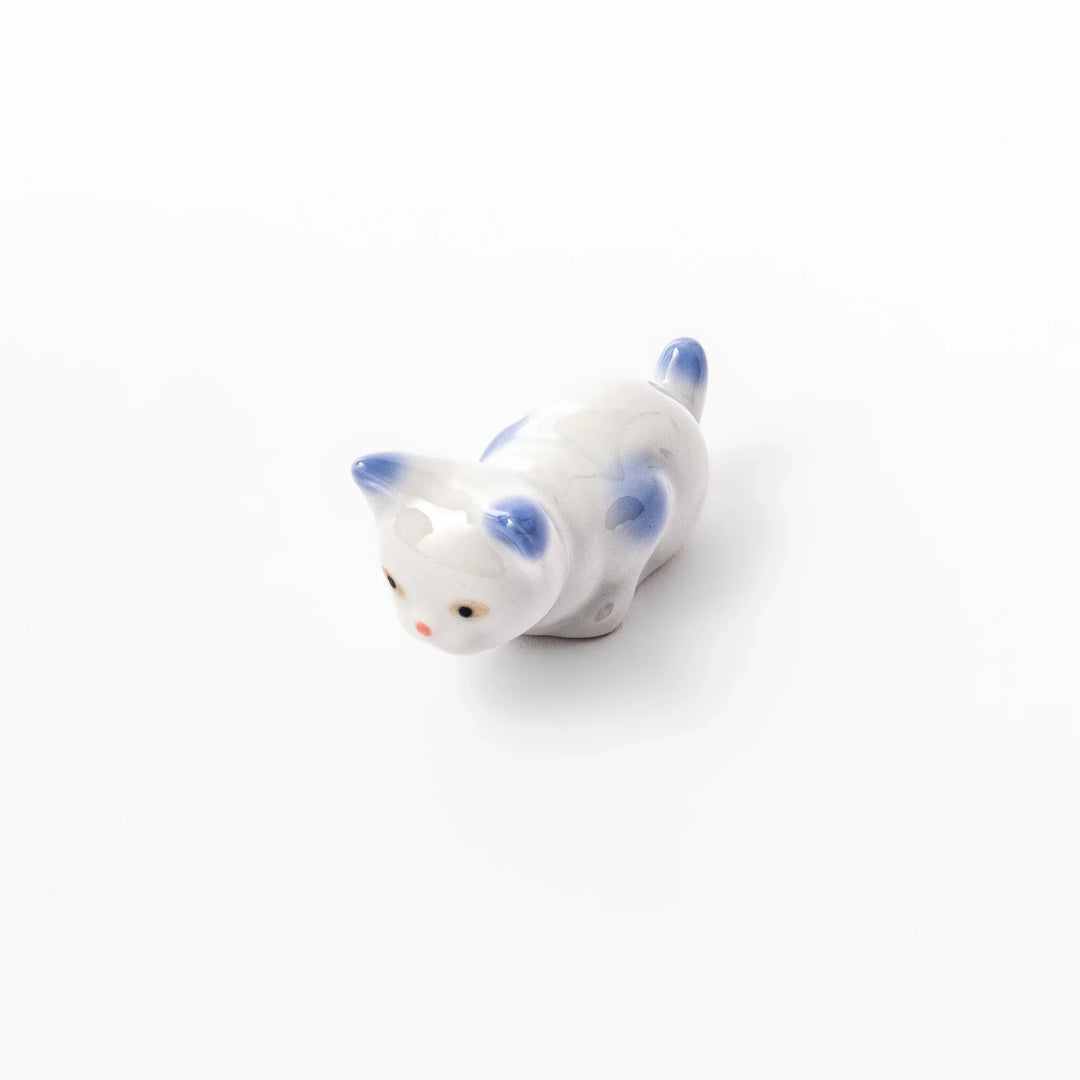 White porcelain kitten-shaped chopstick rest with blue-tipped ears, tail, and body accents, featuring a small red nose.