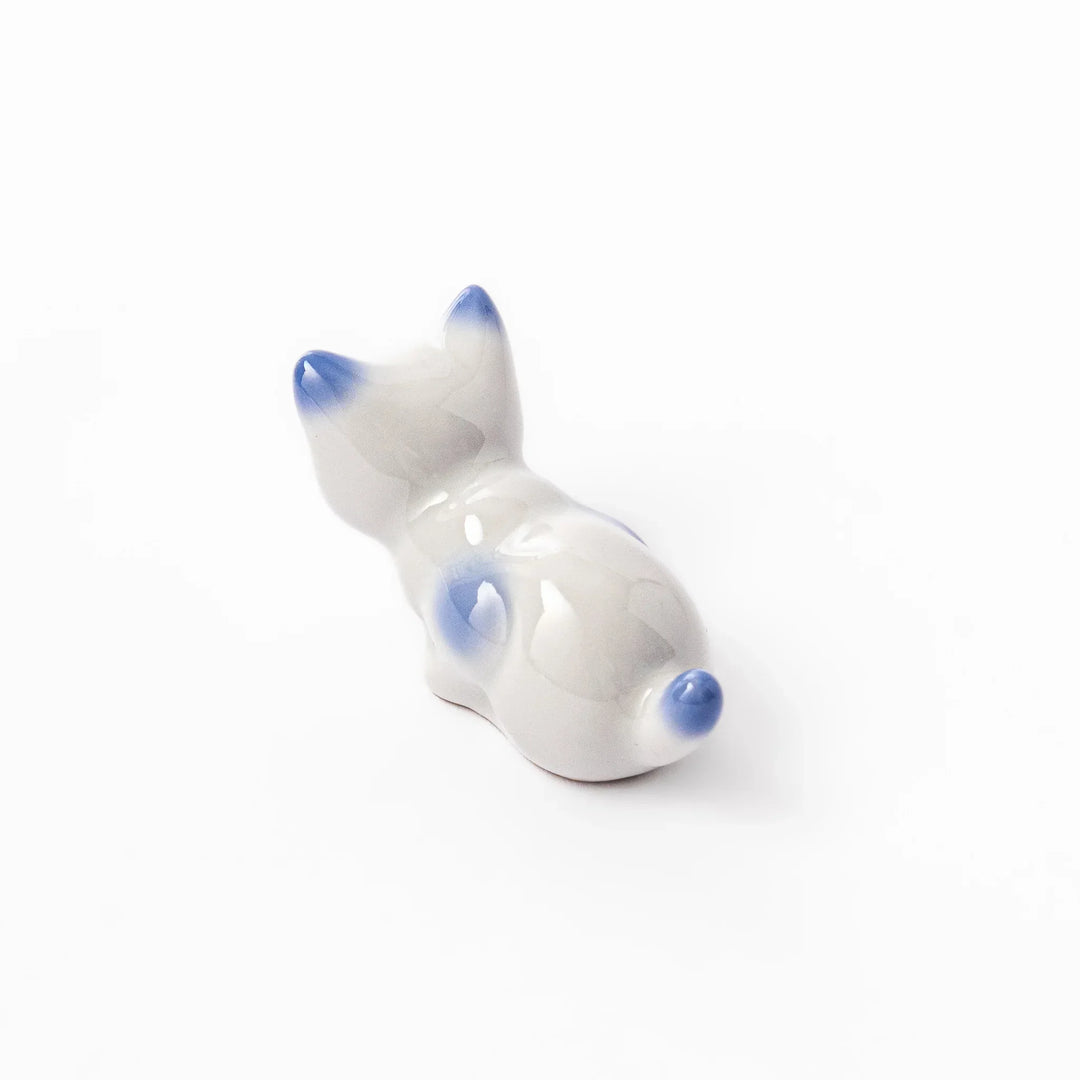 White porcelain kitten-shaped chopstick rest with blue-tipped ears, tail, and body accents, featuring a small red nose.